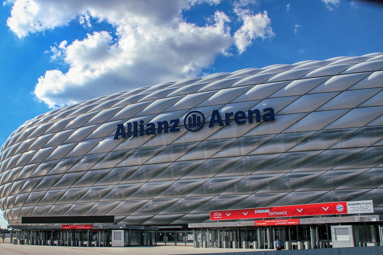 Fachada da Allianz Arena, em Munique, com painéis prateados sob céu azul