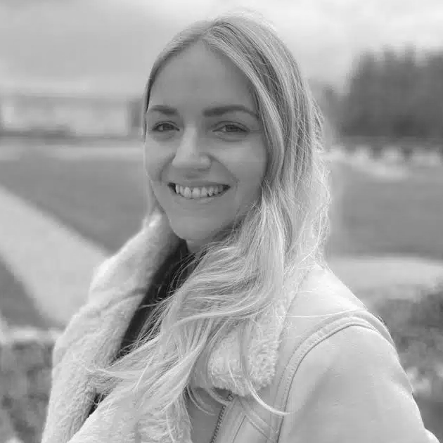 Rafaella-Vilafranca Foto em preto e branco de uma mulher sorrindo, transmitindo alegria e positividade.