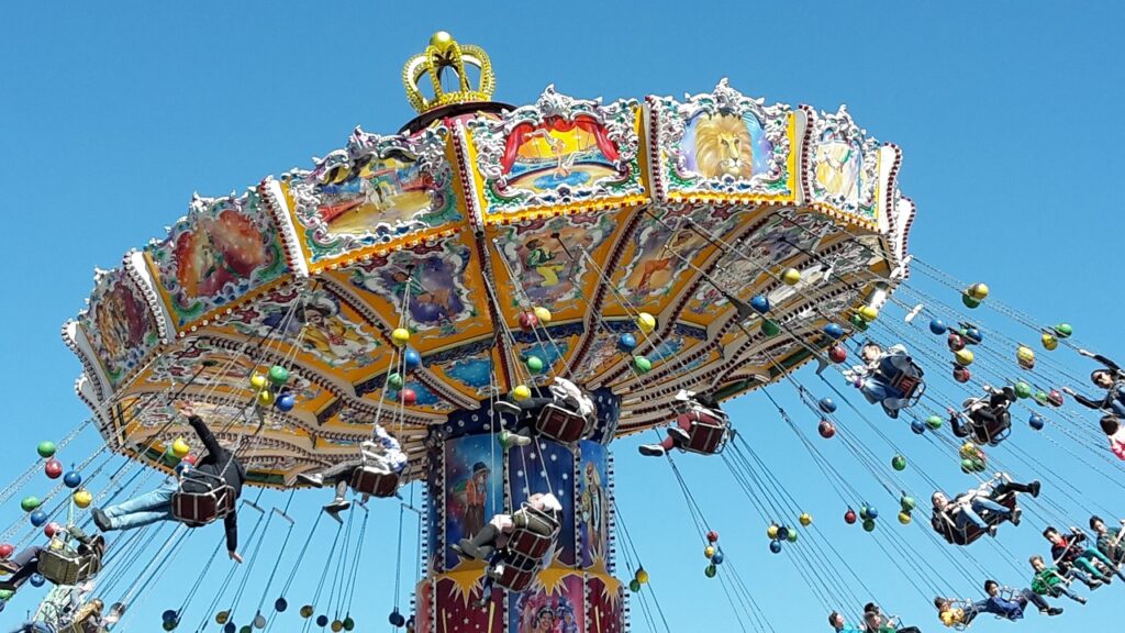 Carrusel de columpios girando contra el cielo azul en el parque de atracciones de la Oktoberfest