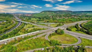 Trecho da Autobahn alemã serpenteando pela paisagem, com carros em movimento