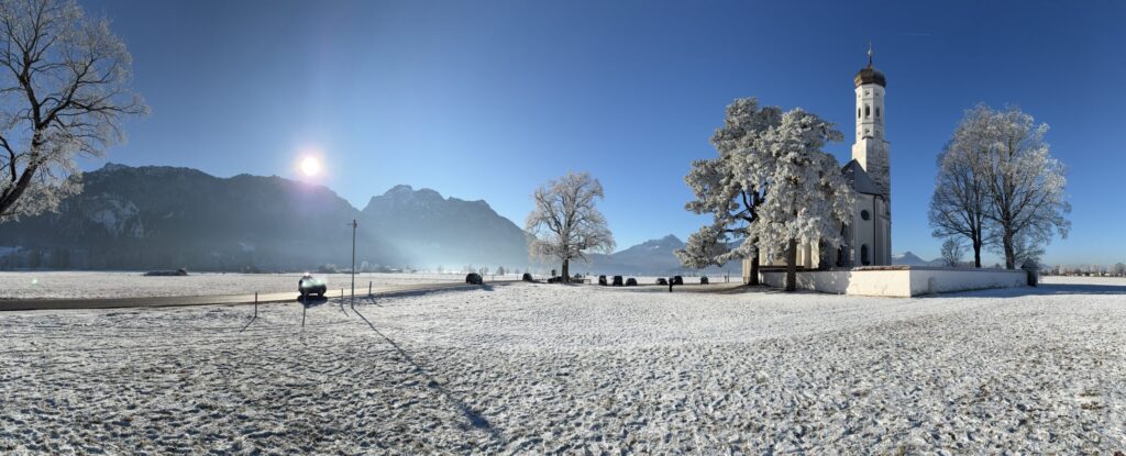 Igreja de São Colomano (St. Coloman) na neve, perto de Schwangau, com os Alpes ao fundo