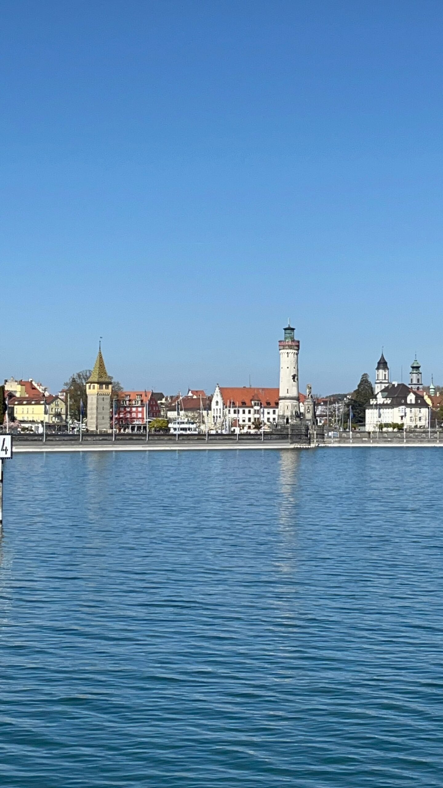 Silhueta de Lindau vista da água, com o farol e a torre Mangturm
