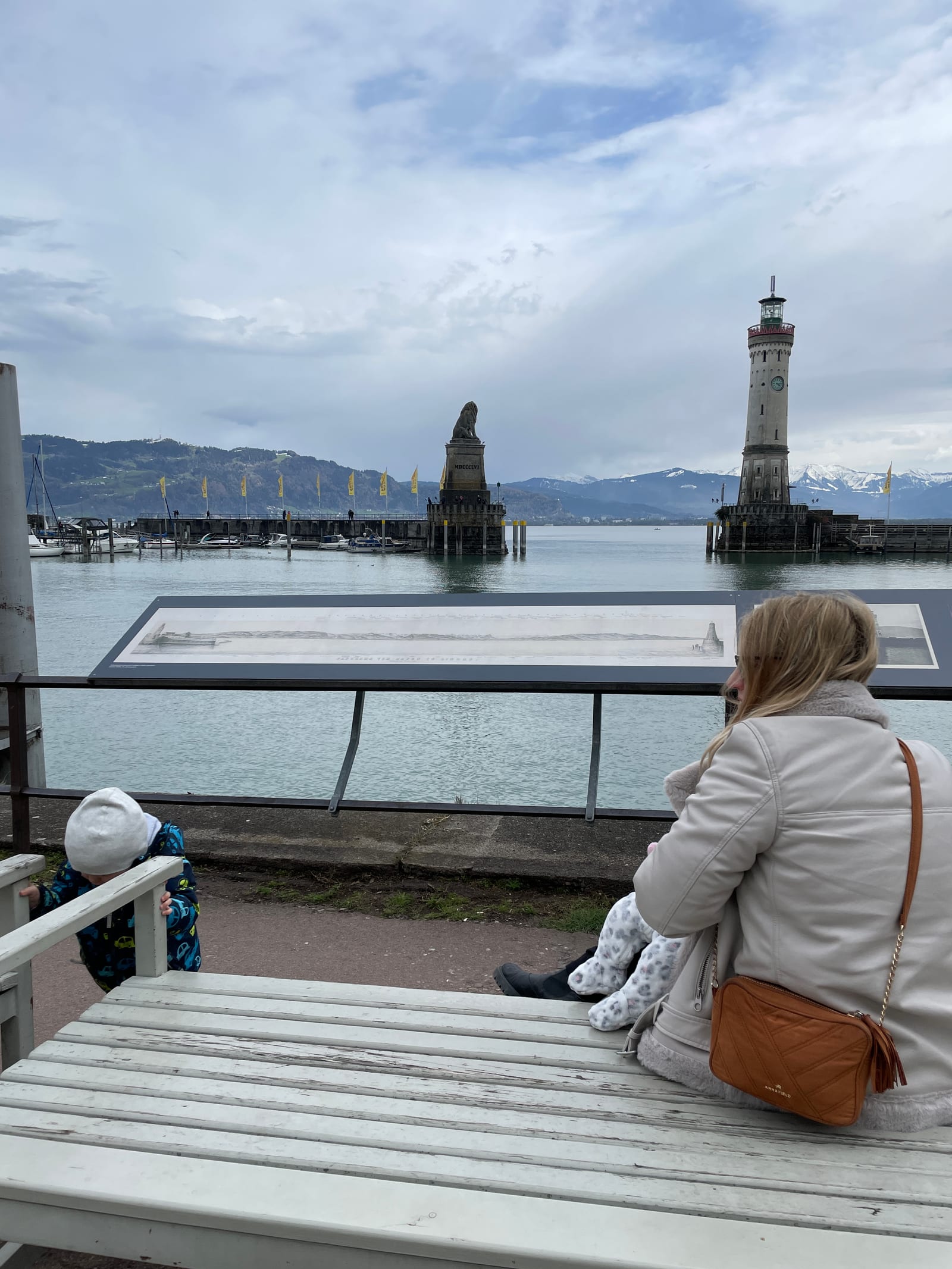 Mirante do porto de Lindau com o farol, o Leão da Baviera e os Alpes nevados ao fundo