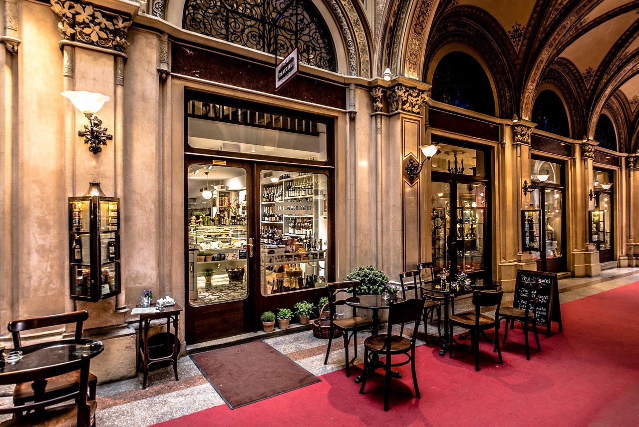 Salão de um café histórico vienense, com arcadas e mesas de mármore
