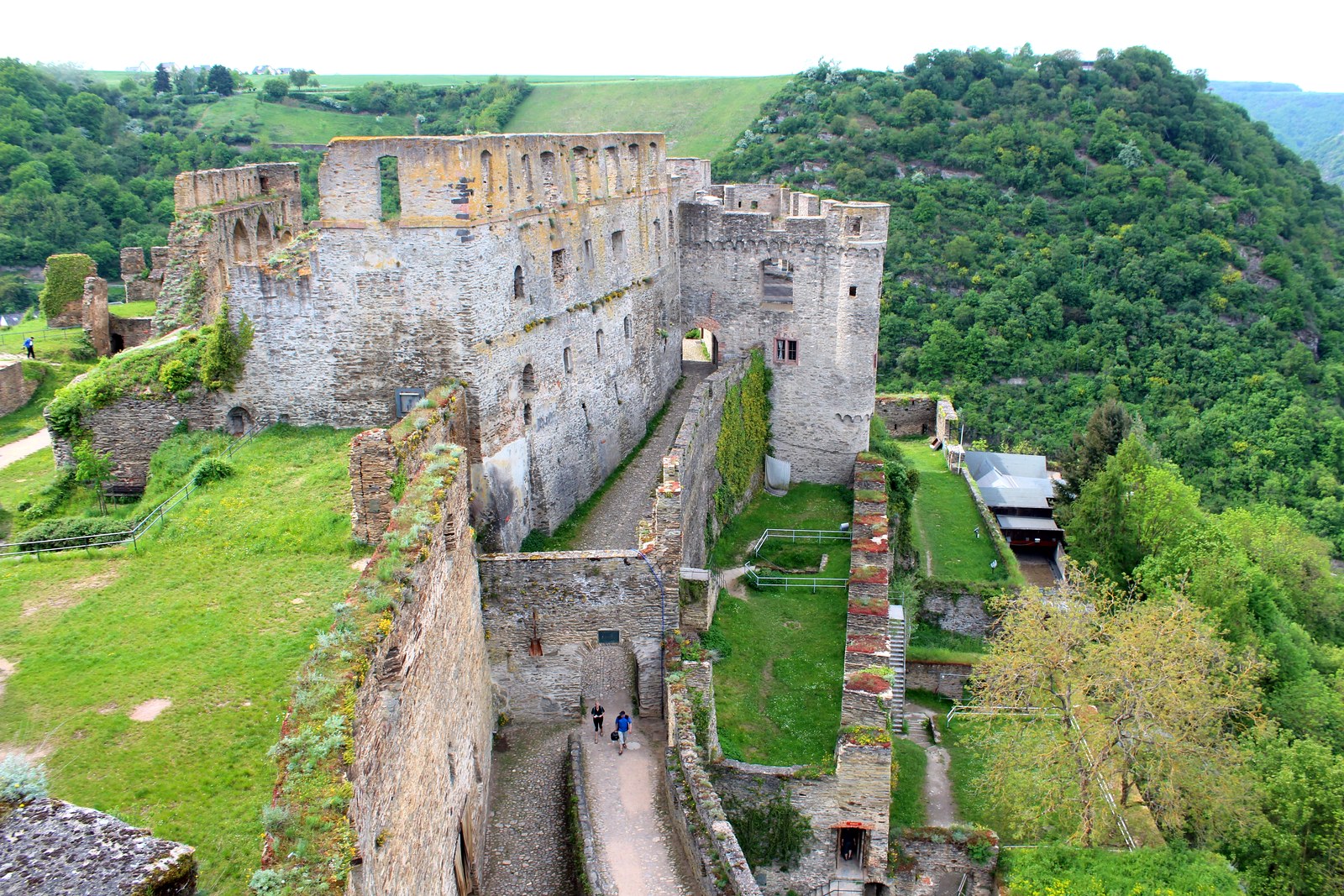 Vista do alto sobre as ruínas de Burg Rheinfels, com a torre redonda e as colinas do vale