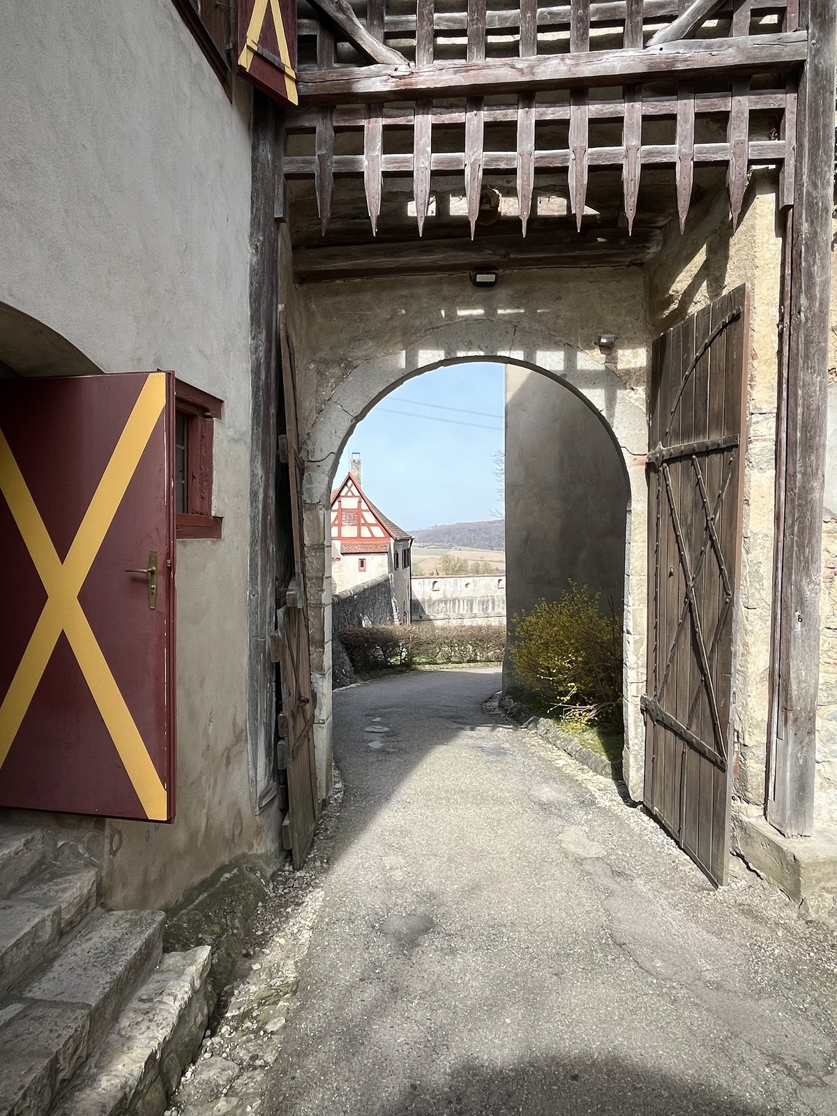 Portão de entrada do Castelo de Harburg com galeria de madeira e porta marcada com X vermelho e amarelo