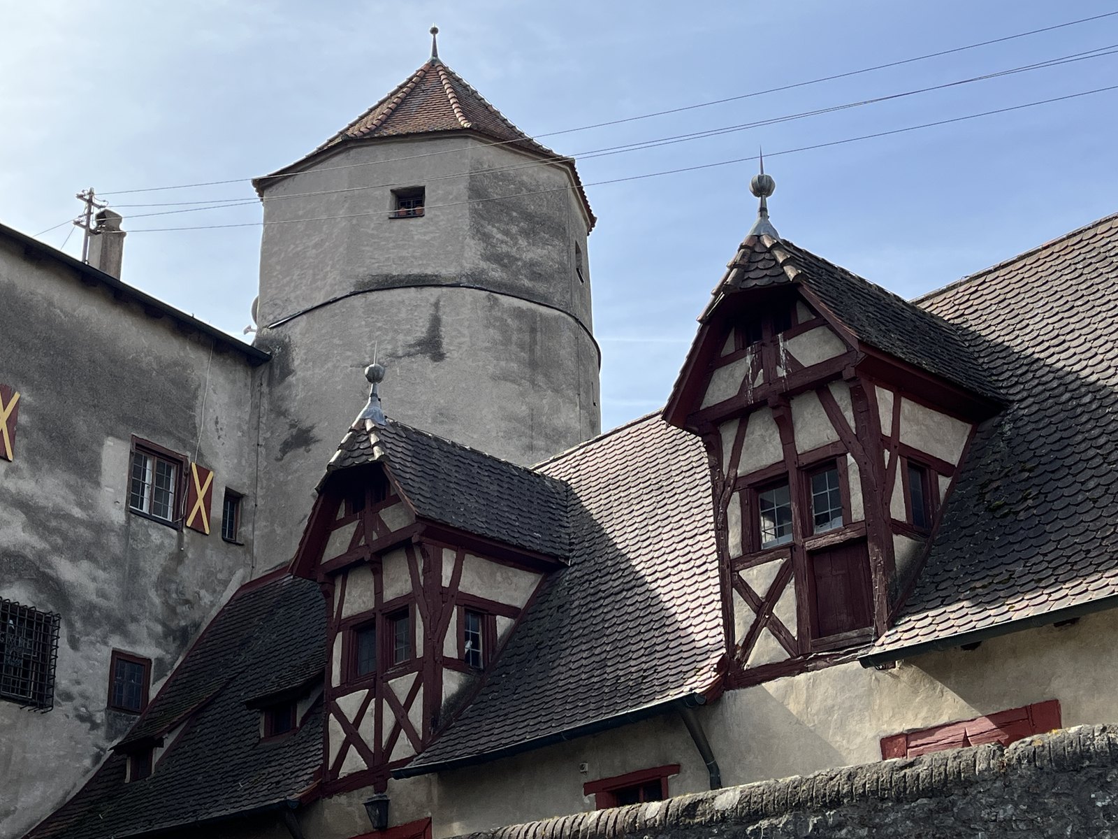Torre do relógio do Castelo de Harburg com sacada de enxaimel em dia de céu azul