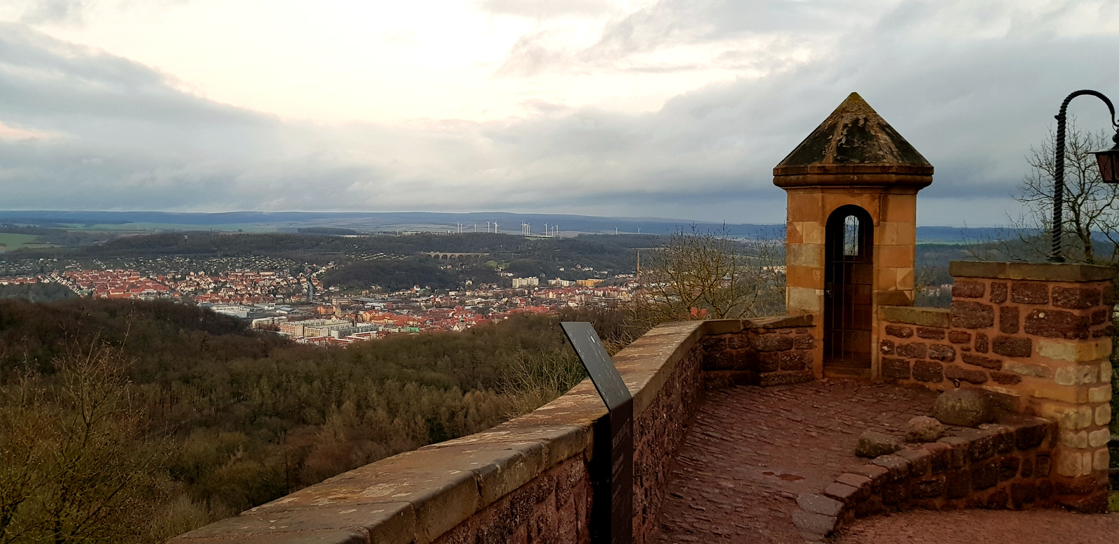 Vista de Eisenach e do vale da Turíngia a partir da muralha do Wartburg, com torreão de pedra em primeiro plano