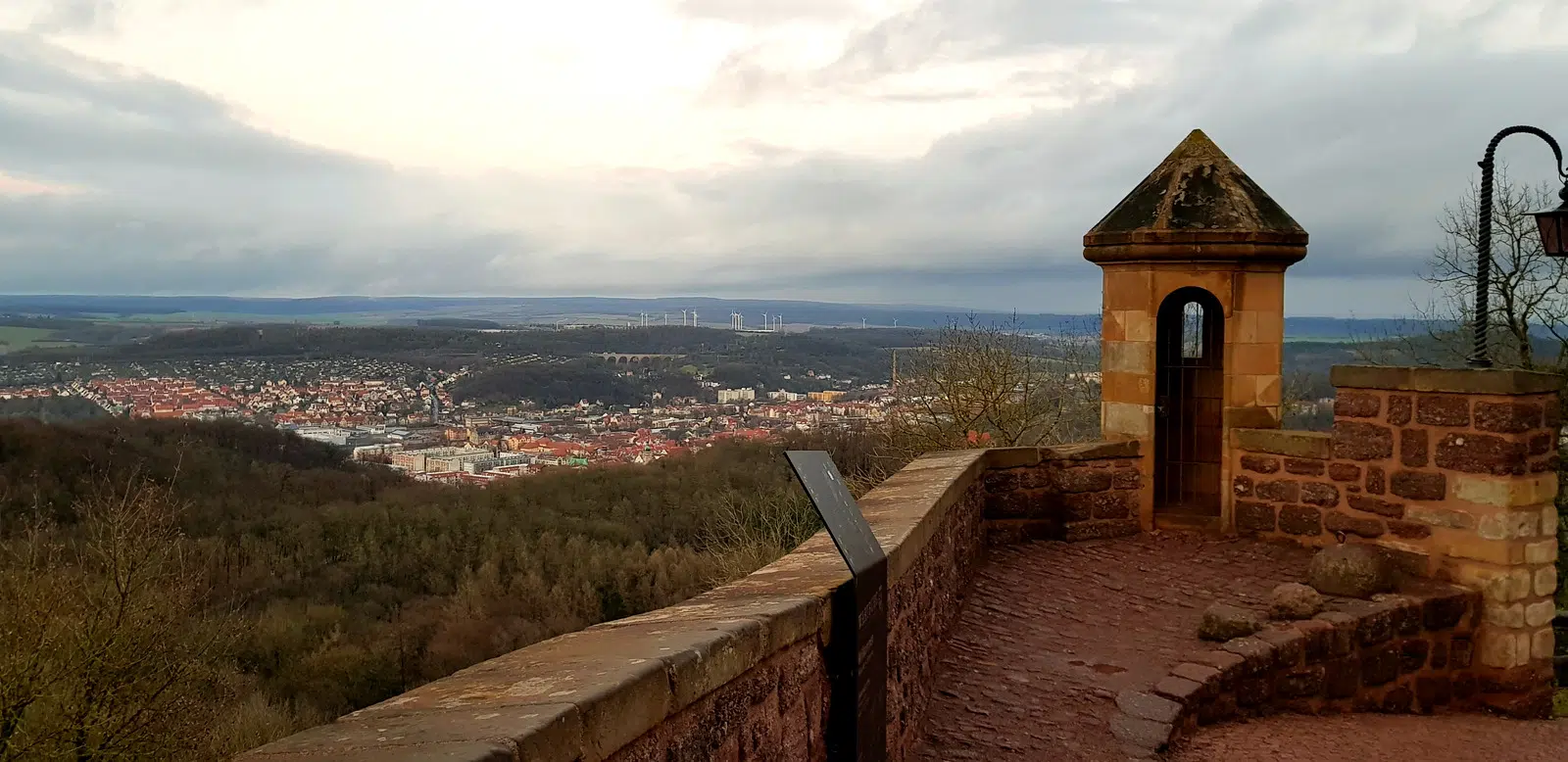 Vista de Eisenach e do vale da Turíngia a partir da muralha do Wartburg, com torreão de pedra em primeiro plano