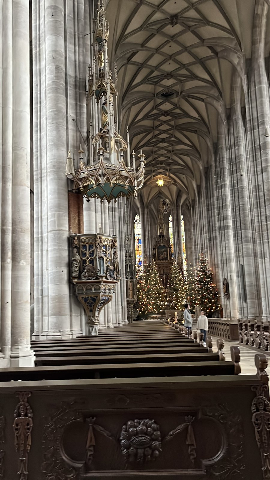 Interior do Münster St. Georg com árvores de Natal iluminadas junto ao altar