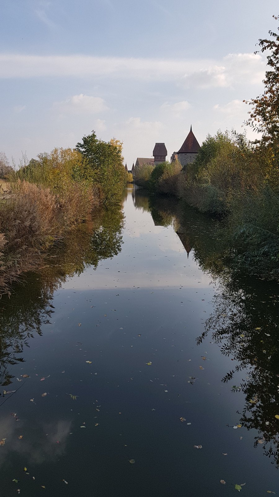 Canal do fosso de Dinkelsbühl com torres da muralha refletidas ao longe