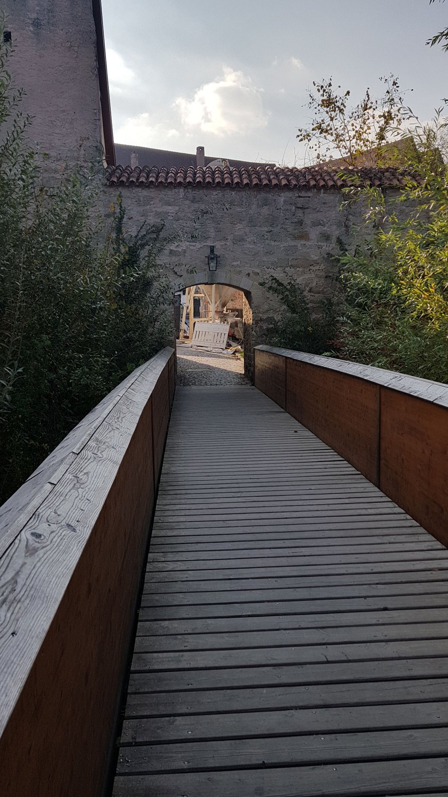 Ponte de madeira sobre o fosso levando a uma passagem na muralha de Dinkelsbühl