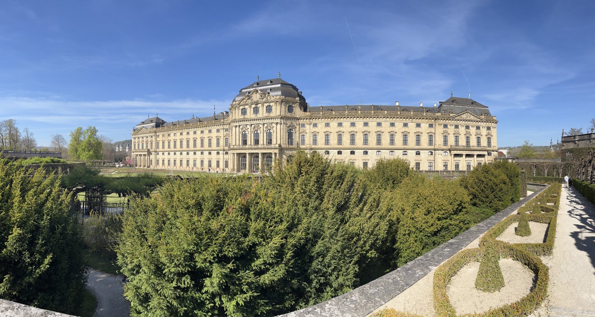 Residência de Würzburg vista do Hofgarten, com a fachada barroca ao fundo e as sebes e canteiros do jardim em primeiro plano