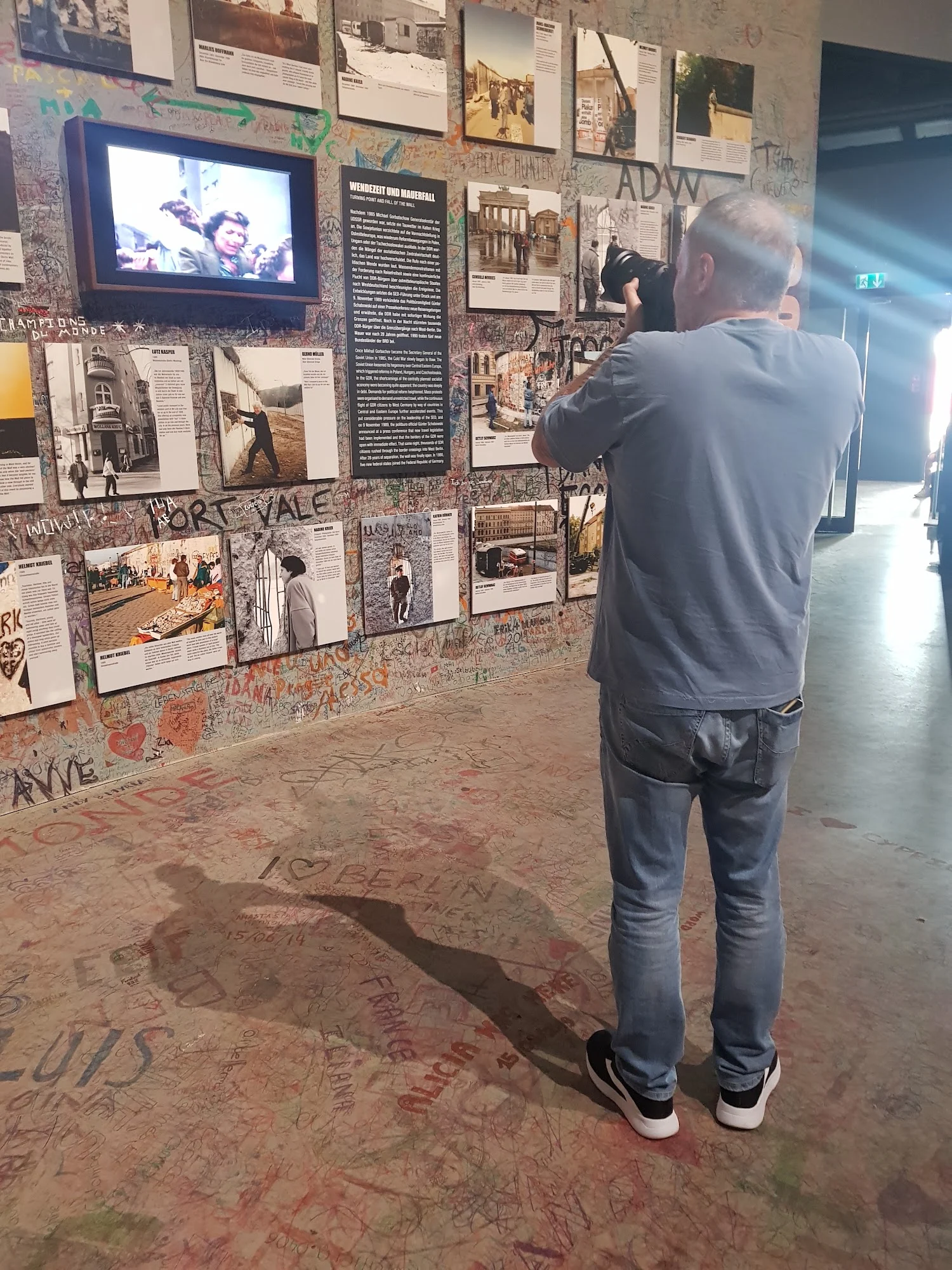 Visita a uma exposição com fotografias e documentos históricos nas paredes