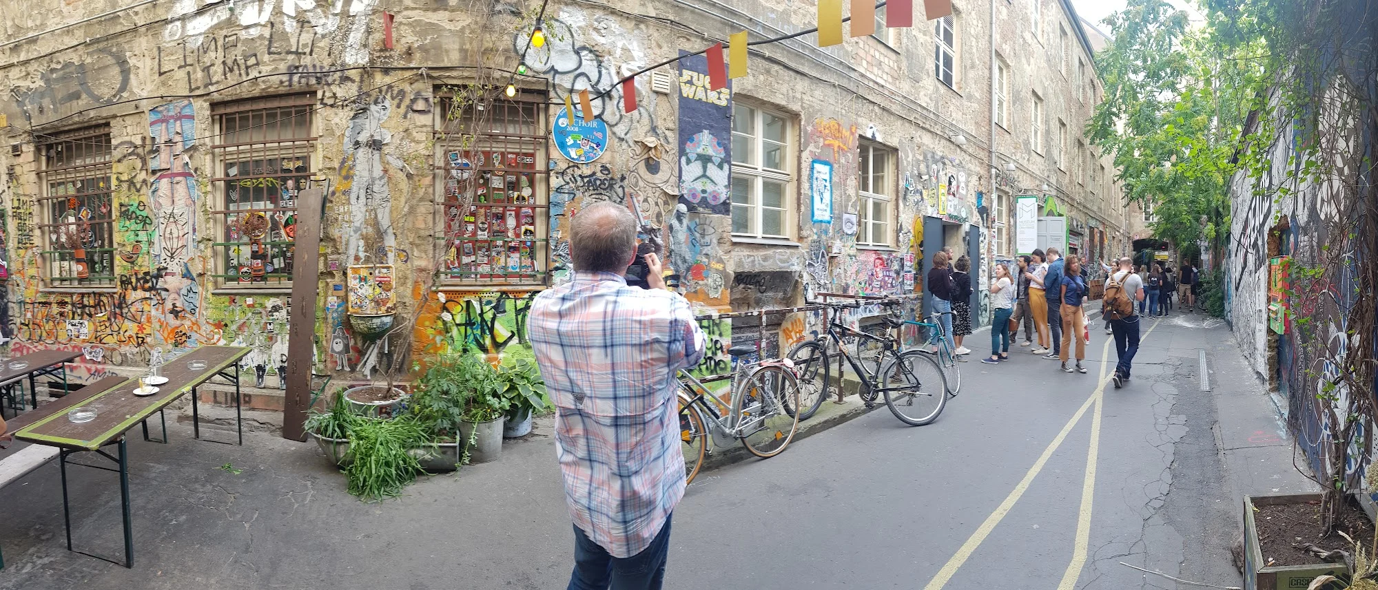 Pátio em Berlim com murais, bicicletas e pessoas caminhando