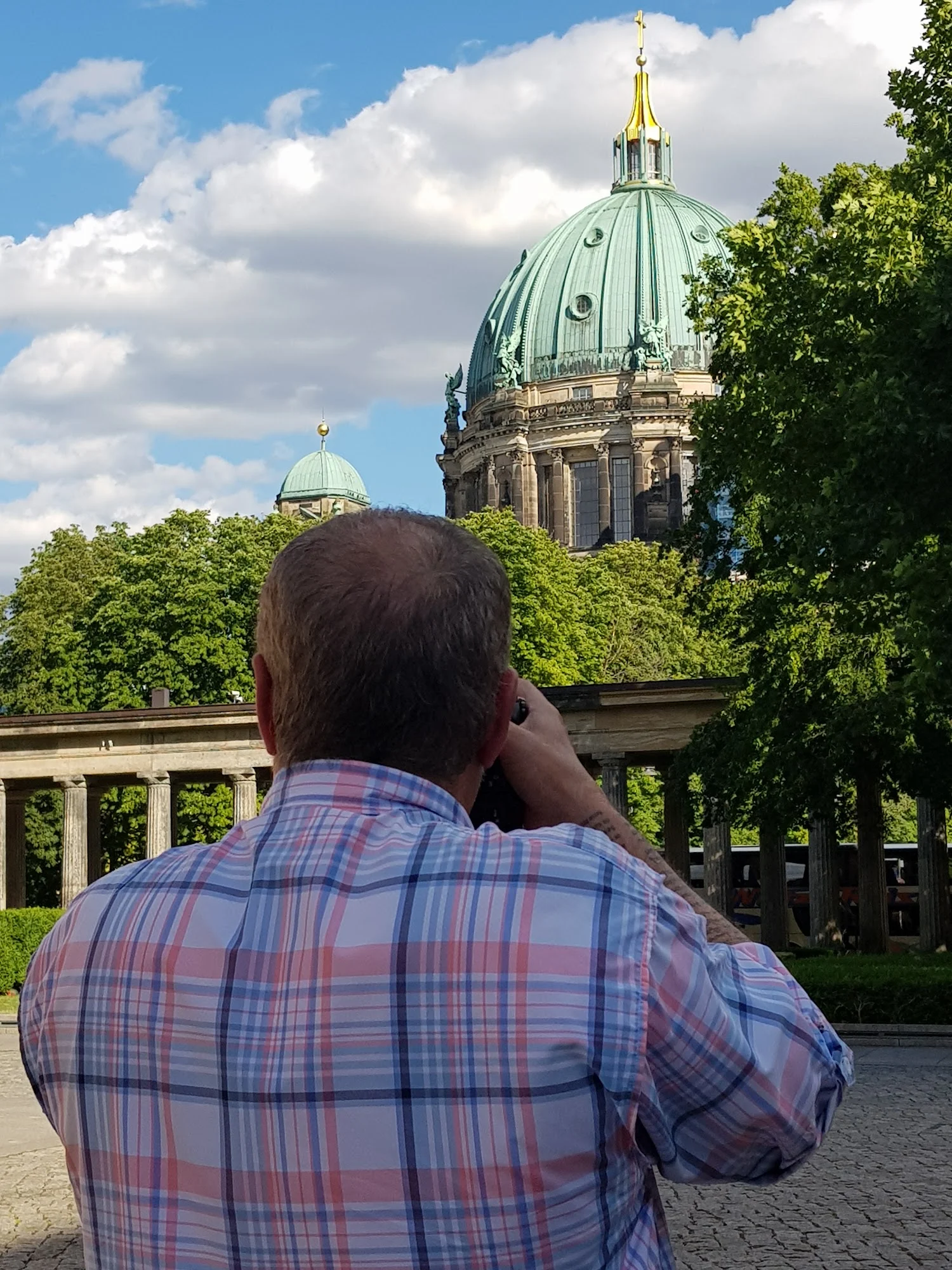 Registro fotográfico da cúpula da Catedral de Berlim entre árvores