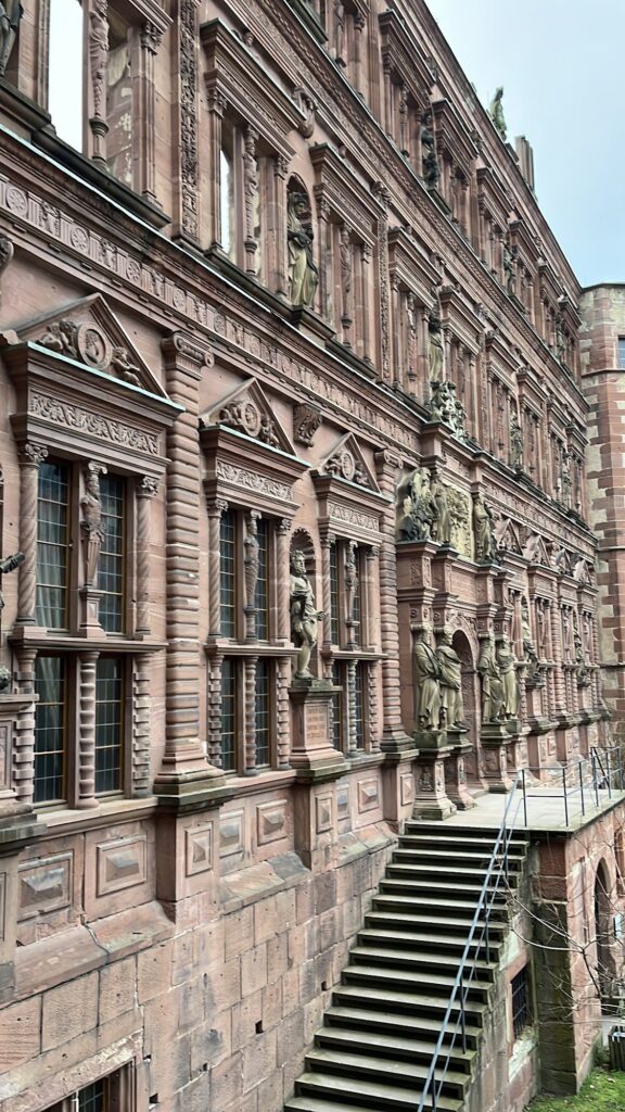 Fachada renascentista do Ottheinrichsbau no Castelo de Heidelberg, com estátuas, janelas vazias e a escada do portal