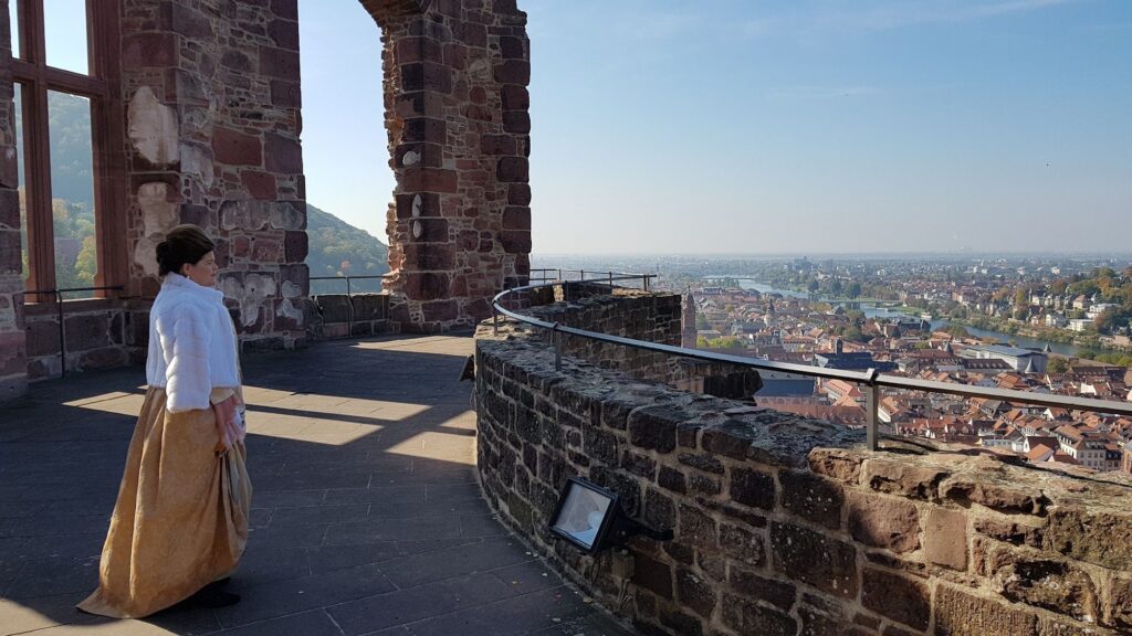 Guia com traje de época no terraço do Castelo de Heidelberg, com vista para a cidade