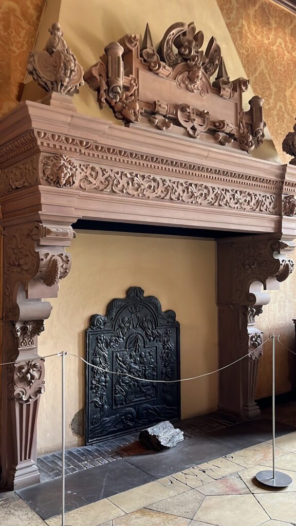 Lareira de pedra esculpida com placa de ferro fundido no interior do Castelo de Heidelberg