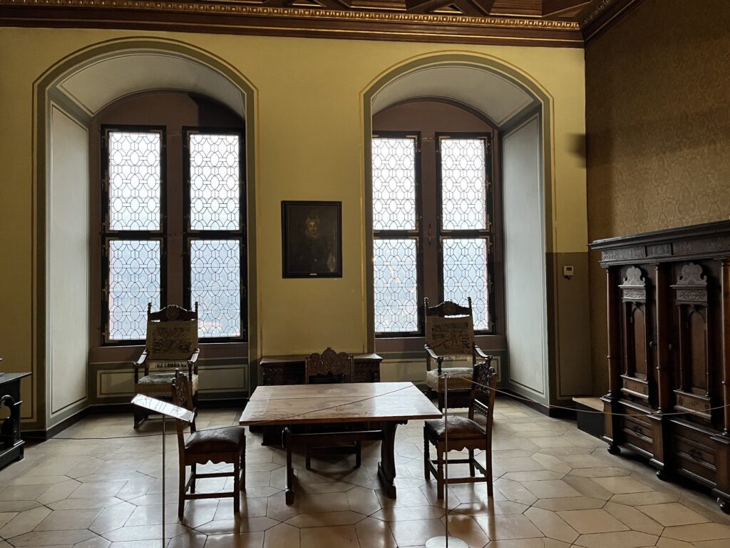 Sala com janelas de vitral e móveis entalhados no interior do Castelo de Heidelberg