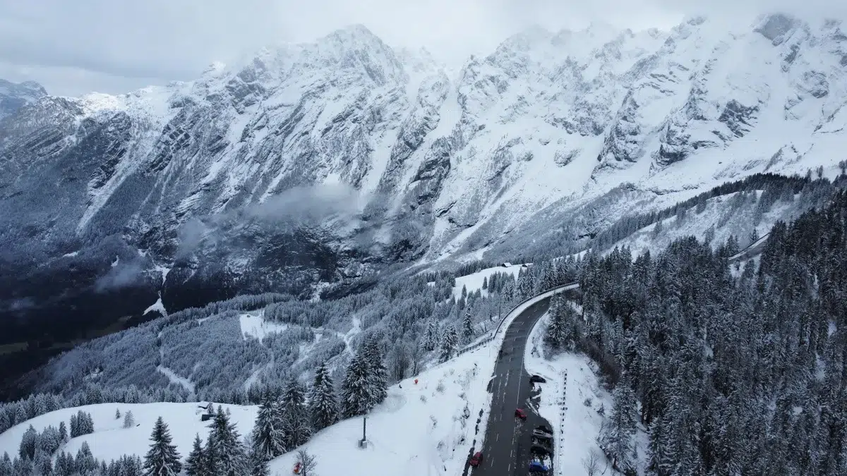 Estrada entre montanhas e encostas cobertas de neve nos Alpes