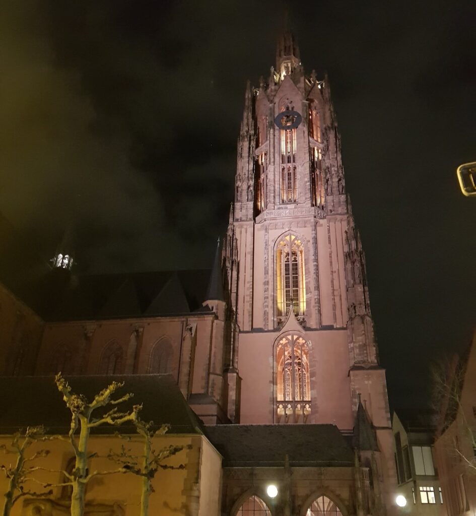Torre gótica da Catedral de São Bartolomeu (Kaiserdom) iluminada à noite, no centro de Frankfurt