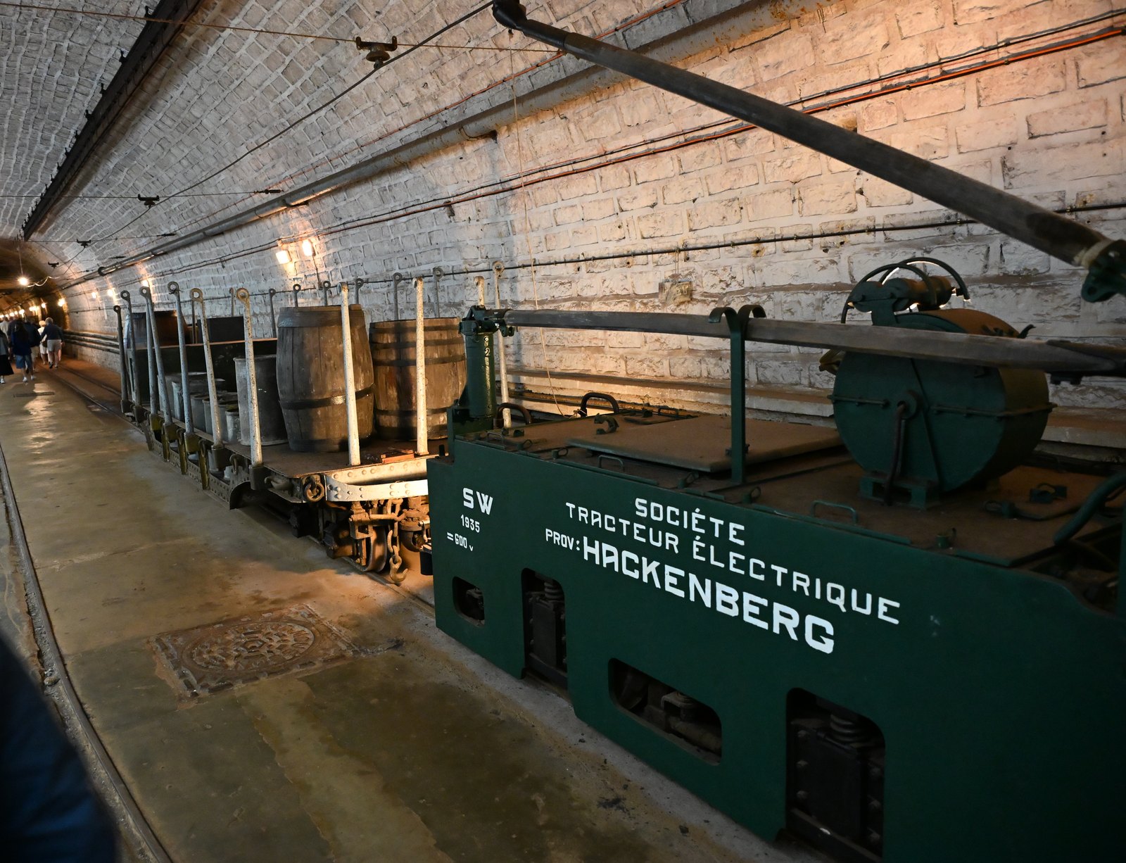 Locomotiva elétrica verde de 1935 do forte de Hackenberg na galeria principal, com o nome Hackenberg pintado na lateral e vagões com barris atrás