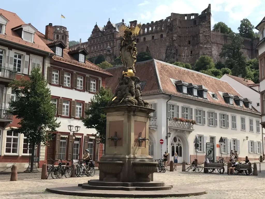 Fonte no Kornmarkt com o Castelo de Heidelberg acima dos telhados