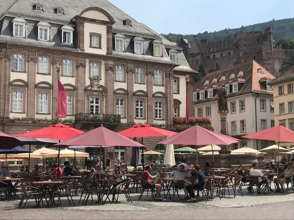 Mesas de cafés no Marktplatz, com a prefeitura e o castelo ao fundo