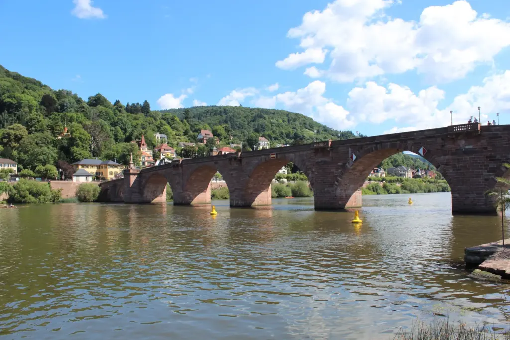 Arcos de pedra da Ponte Velha de Heidelberg vistos da margem do Neckar