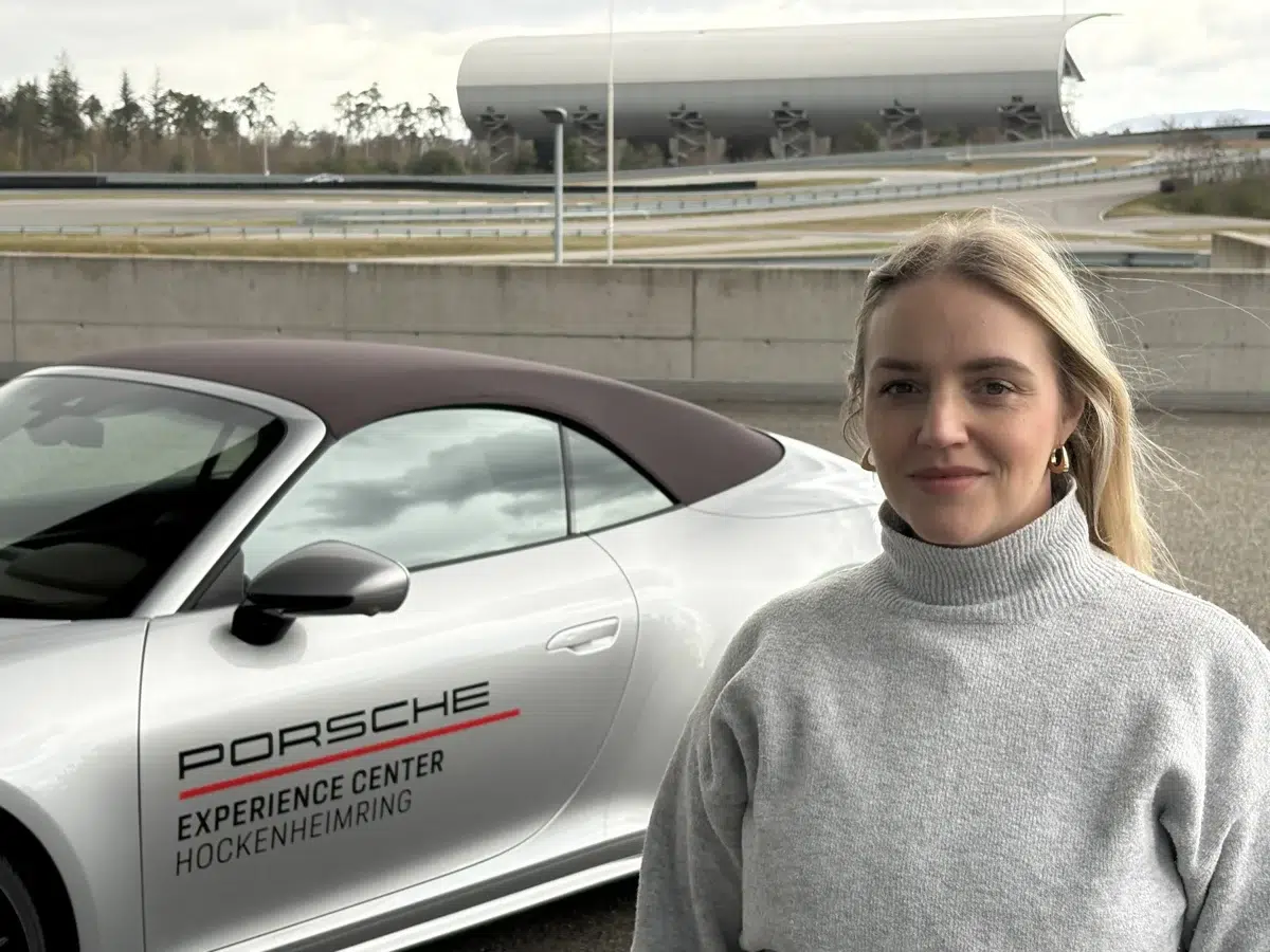 Rafaella ao lado de um Porsche no Porsche Experience Center Hockenheimring
