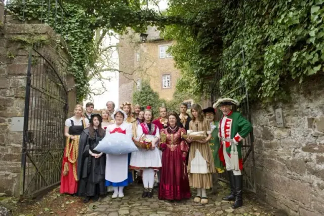 Personagens da Rota dos Contos de Fadas diante de uma construção histórica