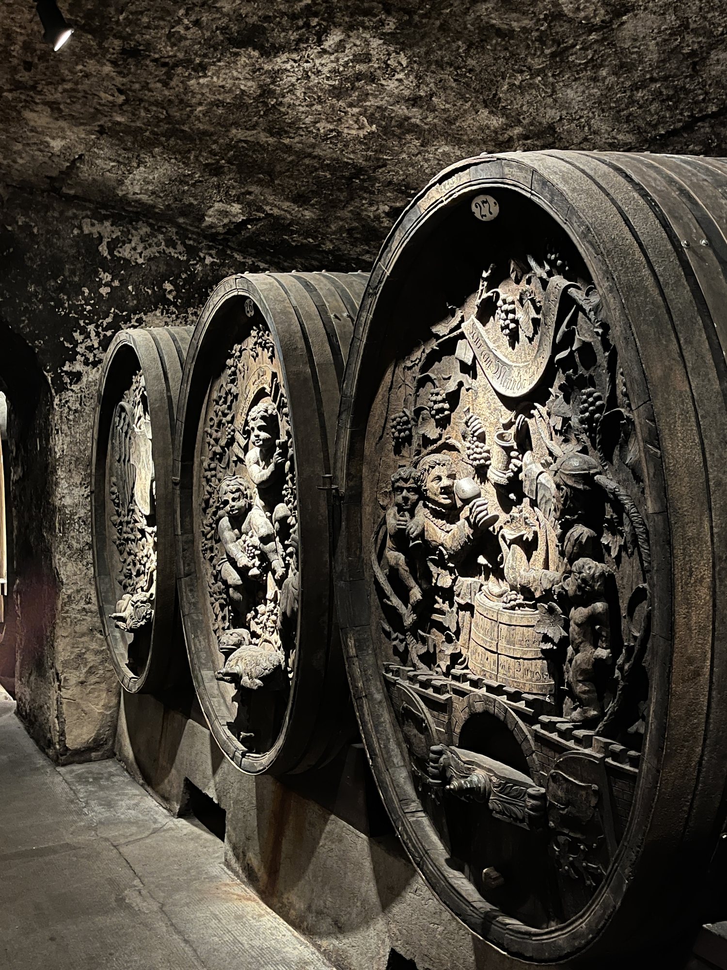 Barris de madeira com tampas esculpidas em relevo na adega histórica do Juliusspital, em Würzburg