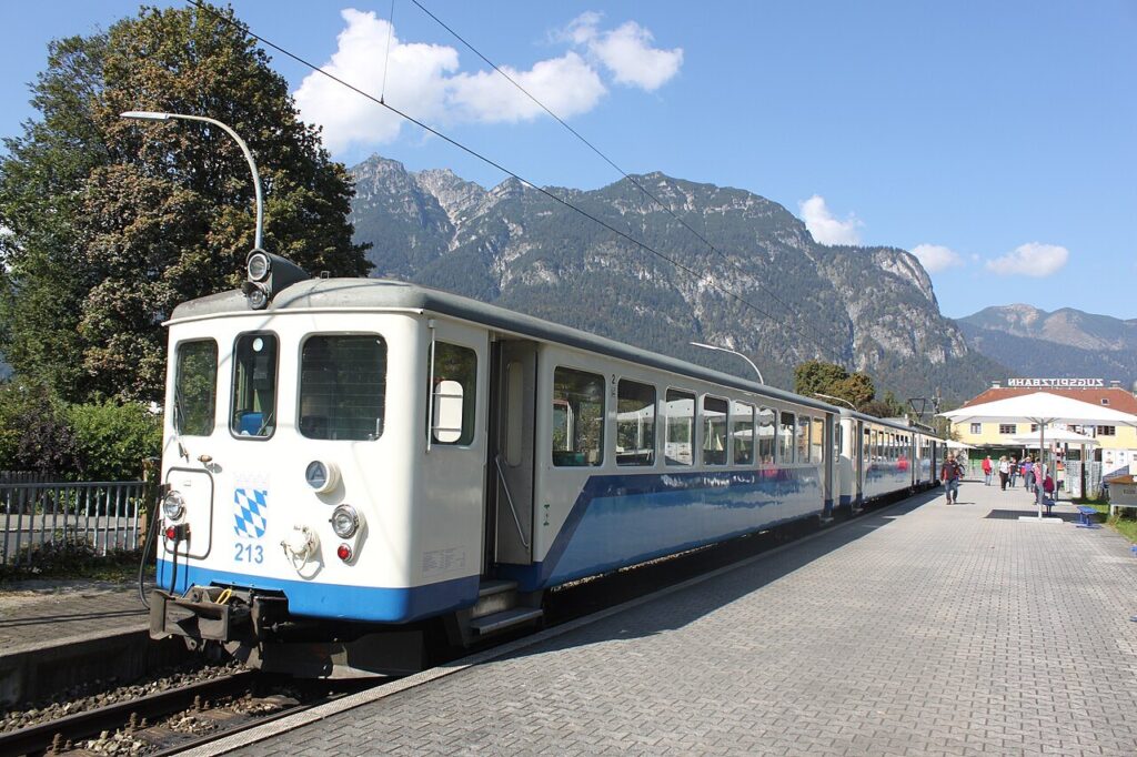 Trem de cremalheira da Zugspitzbahn na estação de Garmisch-Partenkirchen, com montanhas ao fundo