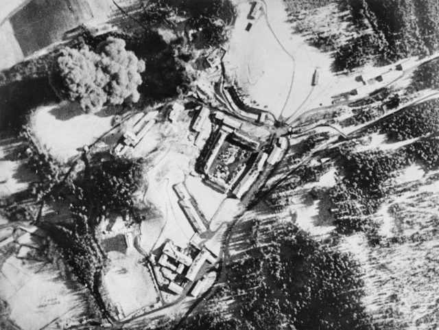 Vista aérea em preto e branco do Obersalzberg com uma explosão perto da residência de Hitler