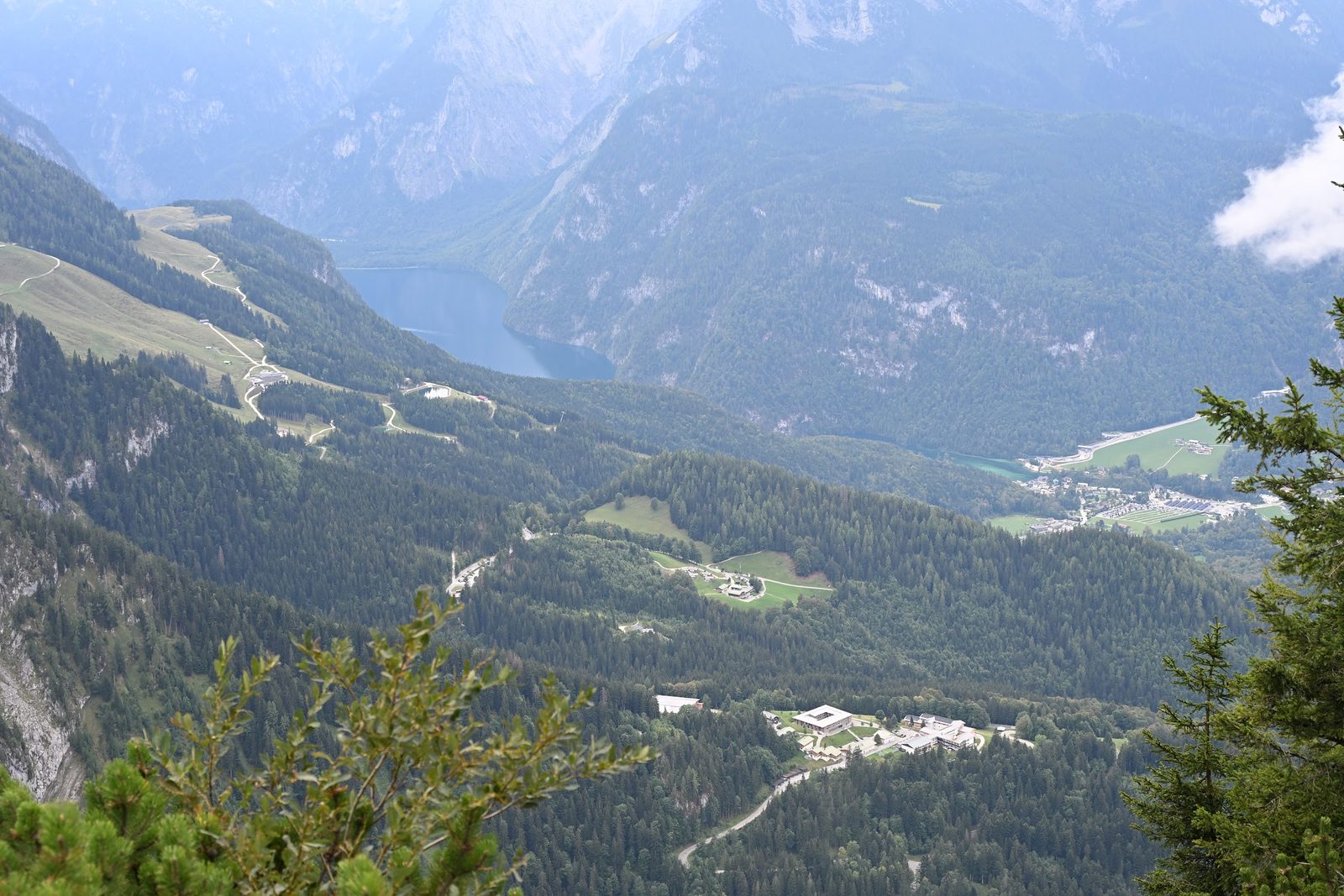 Vista do Kehlstein sobre vales e florestas, com o Königssee estreito entre montanhas ao fundo e nuvens baixas