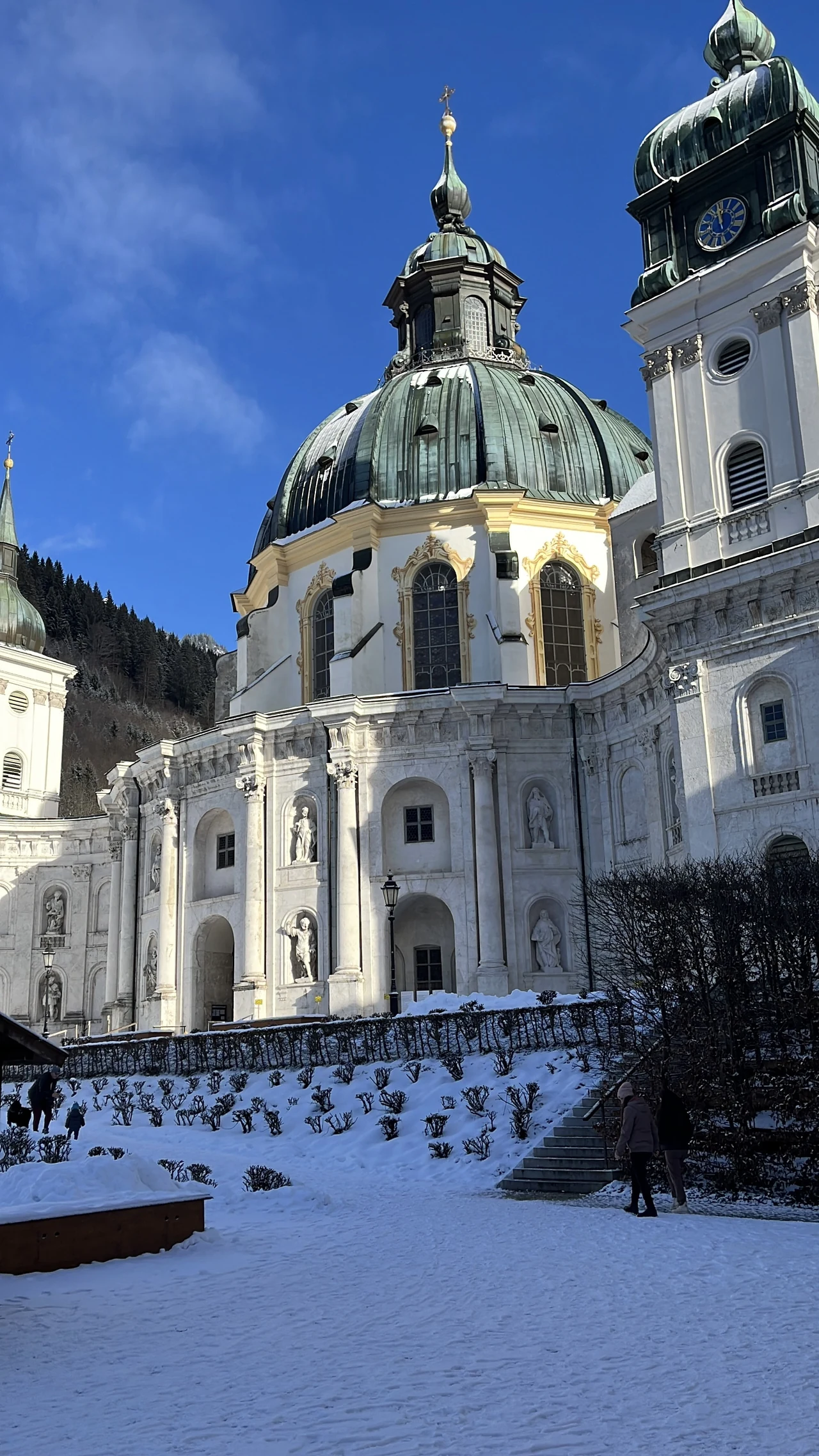 Cúpulas e torres da Abadia de Ettal acima de uma praça coberta de neve