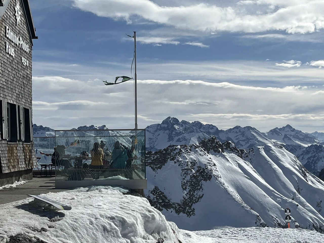 Terraço junto ao Edmund-Probst-Haus na região do Nebelhorn, diante de picos alpinos com neve