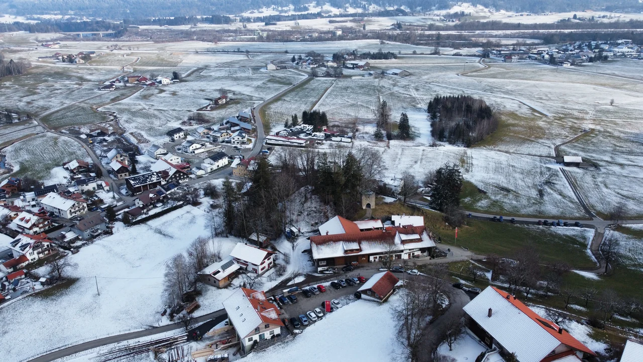 Campos, casas e estradas com neve parcial vistos do alto na região de Immenstadt