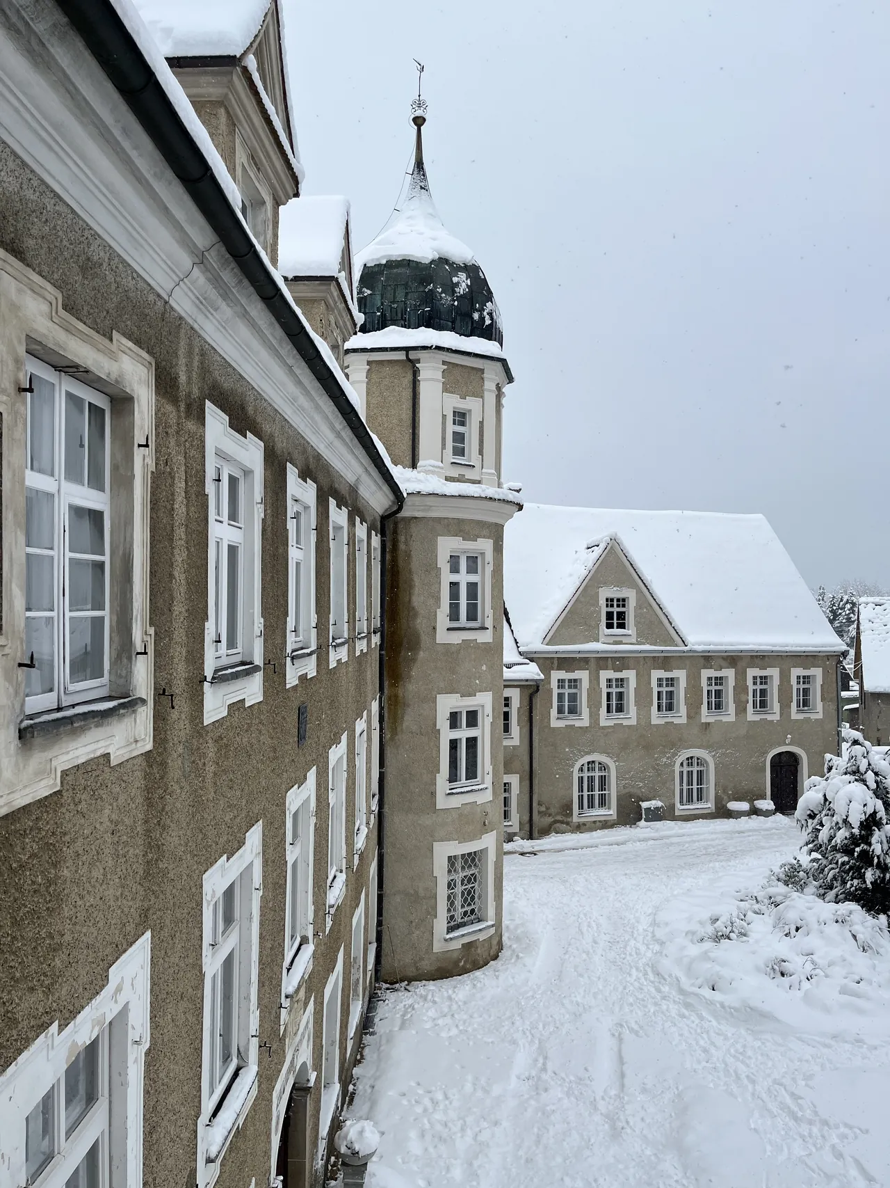 Fachadas do palácio de Hürbel e seu pátio cobertos de neve