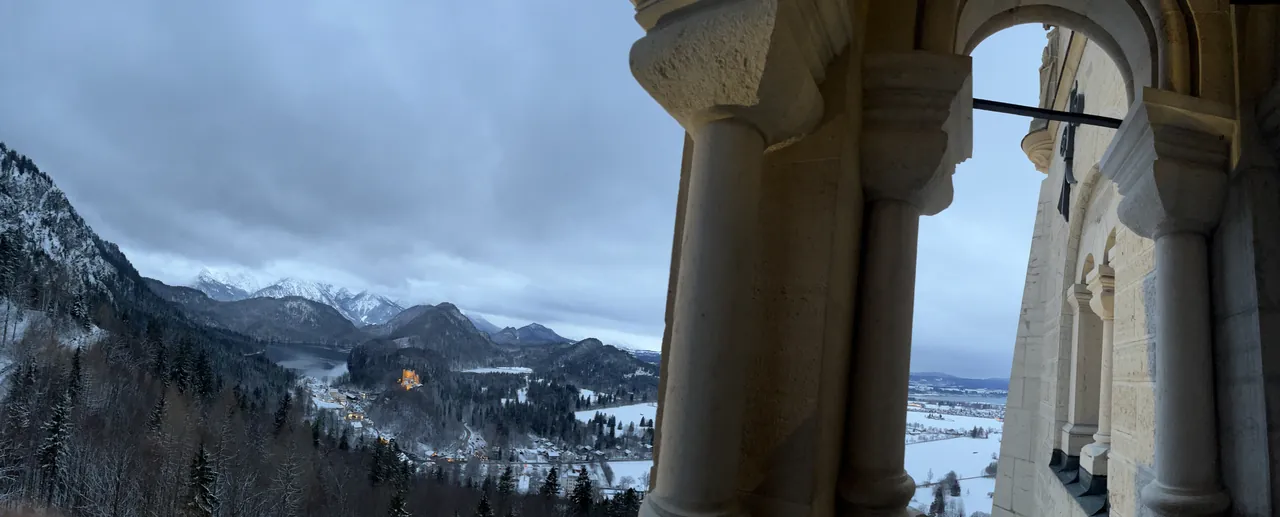 Vista panorâmica dos Alpes e do vale de Schwangau através de uma galeria com arcos